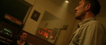 Movie still from “Irreversible” (2002), directed by Gaspar Noé – A person taking a picture of a room with a mirror; Medium shot, Low angle