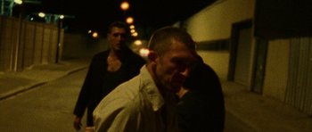 Movie still from “Irreversible” (2002), directed by Gaspar Noé – A man in a white dress shirt and a man in a black shirt; Medium shot, Over the shoulder angle