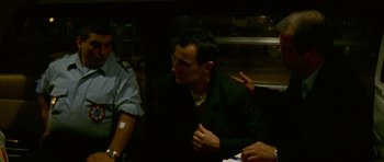 Movie still from “Irreversible” (2002), directed by Gaspar Noé – A man sitting at a table in front of other people; Medium shot, High angle