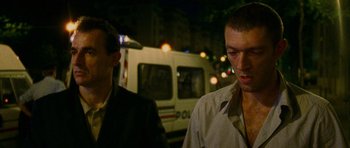 Movie still from “Irreversible” (2002), directed by Gaspar Noé – Two men standing next to each other on the street; Close Up shot, Low angle