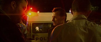 Movie still from “Irreversible” (2002), directed by Gaspar Noé – A man standing in front of a police car; Close Up shot, Low angle