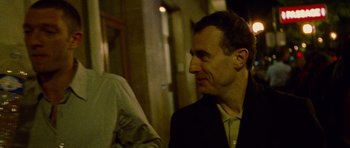 Movie still from “Irreversible” (2002), directed by Gaspar Noé – A person wearing a suit and tie; Close Up shot, Over the shoulder angle