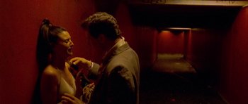 Movie still from “Irreversible” (2002), directed by Gaspar Noé – A man in a suit and tie fixing another man's tie; Medium shot, Over the shoulder angle