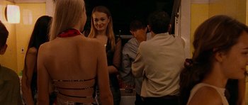Movie still from “Irreversible” (2002), directed by Gaspar Noé – A group of young people standing around a room together; Medium shot, Over the shoulder angle