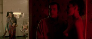Movie still from “Irreversible” (2002), directed by Gaspar Noé – A man standing in a room in the dark; Medium shot, Over the shoulder angle