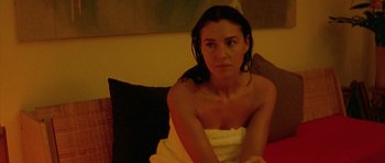 Movie still from “Irreversible” (2002), directed by Gaspar Noé – A woman wrapped in a towel sitting on top of a couch; Close Up shot, High angle