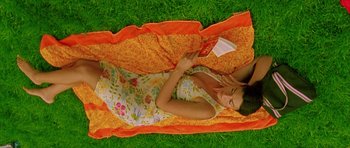 Movie still from “Irreversible” (2002), directed by Gaspar Noé – A woman laying on the grass talking on a cell phone; Medium shot, Overhead angle
