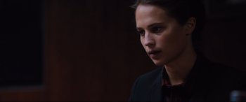 Movie still from “Jason Bourne” (2016), directed by Paul Greengrass – A woman in a black jacket looking to her left; Close Up shot, Over the shoulder angle