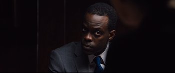 Movie still from “Jason Bourne” (2016), directed by Paul Greengrass – A man in a suit and tie looking to his left; Close Up shot, Over the shoulder angle