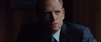 Movie still from “Jason Bourne” (2016), directed by Paul Greengrass – A person wearing a suit and tie; Close Up shot, Over the shoulder angle