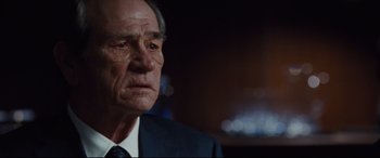 Movie still from “Jason Bourne” (2016), directed by Paul Greengrass – An older man wearing a suit and tie; Close Up shot, Over the shoulder angle