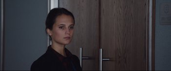 Movie still from “Jason Bourne” (2016), directed by Paul Greengrass – A woman standing in front of a wooden door; Close Up shot, Over the shoulder angle