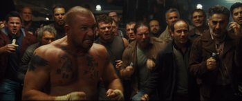 Movie still from “Jason Bourne” (2016), directed by Paul Greengrass – A group of men standing around each other in a room; Medium shot, High angle