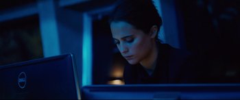 Movie still from “Jason Bourne” (2016), directed by Paul Greengrass – A woman sitting in front of a laptop computer at night; Close Up shot, Over the shoulder angle