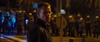 Movie still from “Jason Bourne” (2016), directed by Paul Greengrass – A person standing in front of a group of people; Medium shot, Low angle