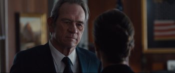 Movie still from “Jason Bourne” (2016), directed by Paul Greengrass – A man wearing a suit and tie talking to a woman wearing a dress suit; Close Up shot, Over the shoulder angle