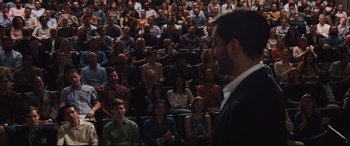 Movie still from “Jason Bourne” (2016), directed by Paul Greengrass – A man standing in front of a crowd of people; Extreme Wide shot, Over the shoulder angle