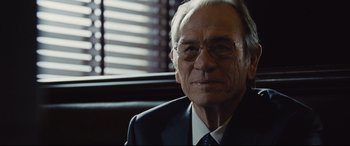 Movie still from “Jason Bourne” (2016), directed by Paul Greengrass – An older man wearing a suit and tie; Close Up shot, Over the shoulder angle