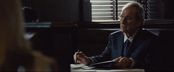 Movie still from “Jason Bourne” (2016), directed by Paul Greengrass – A man sitting at a table with a pen in his hand; Close Up shot, Over the shoulder angle