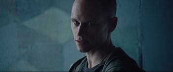 Movie still from “Jason Bourne” (2016), directed by Paul Greengrass – A man with a bald head is looking at the camera; Close Up shot, Low angle
