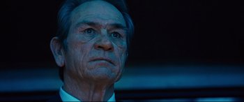 Movie still from “Jason Bourne” (2016), directed by Paul Greengrass – An older man with a blue hair and a white shirt; Close Up shot, Low angle