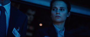 Movie still from “Jason Bourne” (2016), directed by Paul Greengrass – A woman in a suit and tie looking into the distance; Close Up shot, Low angle