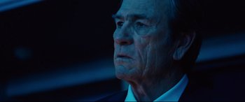 Movie still from “Jason Bourne” (2016), directed by Paul Greengrass – An older man in a white shirt and a black suit; Close Up shot, Low angle
