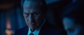 Movie still from “Jason Bourne” (2016), directed by Paul Greengrass – An older man in a suit and tie looking sad; Close Up shot, Low angle