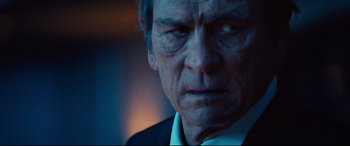 Movie still from “Jason Bourne” (2016), directed by Paul Greengrass – An older man in a white shirt and black jacket; Close Up shot, Over the shoulder angle