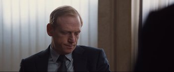 Movie still from “Jason Bourne” (2016), directed by Paul Greengrass – A person wearing a suit and tie; Close Up shot, Over the shoulder angle