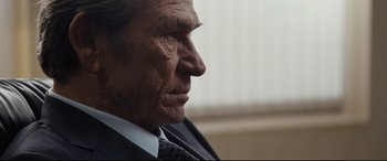 Movie still from “Jason Bourne” (2016), directed by Paul Greengrass – An older man wearing a suit and tie looking to his left; Close Up shot, Over the shoulder angle