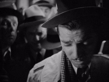 Movie still from “It Happened One Night” (1934), directed by Frank Capra – Black and white photograph of a man wearing a hat; Close Up shot, Over the shoulder angle