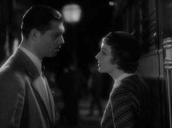 Movie still from “It Happened One Night” (1934), directed by Frank Capra – A man and a woman standing next to each other in front of a building; Close Up shot, Over the shoulder angle