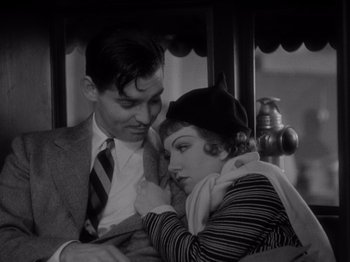 Movie still from “It Happened One Night” (1934), directed by Frank Capra – A man and a woman sitting next to each other on a train; Close Up shot, High angle