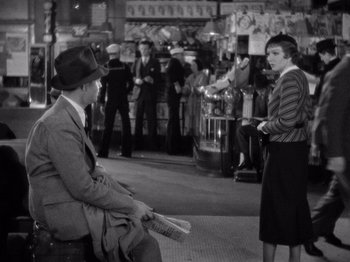 Movie still from “It Happened One Night” (1934), directed by Frank Capra – A man and a woman are sitting on a bench; Wide shot, High angle