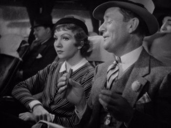 Movie still from “It Happened One Night” (1934), directed by Frank Capra – A man and a woman sitting next to each other; Close Up shot, High angle