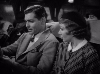 Movie still from “It Happened One Night” (1934), directed by Frank Capra – A man and a woman sitting next to each other; Medium shot, High angle