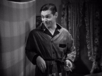 Movie still from “It Happened One Night” (1934), directed by Frank Capra – A black and white photo of a man in a robe; Medium shot, High angle