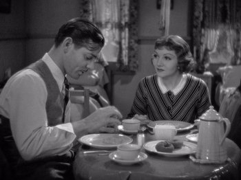 Movie still from “It Happened One Night” (1934), directed by Frank Capra – A man and a woman sitting at a dinner table; Medium shot, High angle