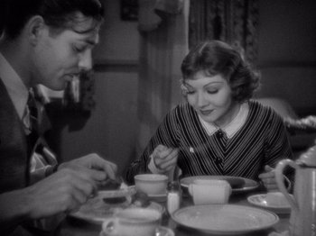 Movie still from “It Happened One Night” (1934), directed by Frank Capra – A man and a woman sitting at a dinner table; Medium shot, High angle
