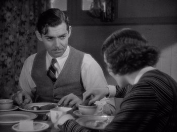 Movie still from “It Happened One Night” (1934), directed by Frank Capra – A man and a woman sitting at a dinner table; Medium shot, Over the shoulder angle