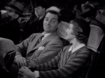 Movie still from “It Happened One Night” (1934), directed by Frank Capra – A man and a woman sitting next to each other; Medium shot, High angle