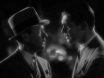 Movie still from “It Happened One Night” (1934), directed by Frank Capra – A couple of men standing next to each other; Close Up shot, Over the shoulder angle