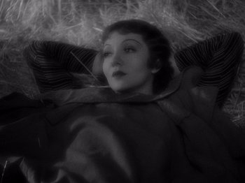Movie still from “It Happened One Night” (1934), directed by Frank Capra – A woman laying on the ground with her eyes closed; Close Up shot, High angle