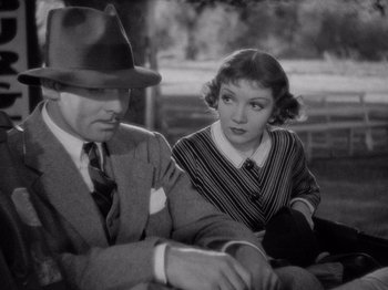 Movie still from “It Happened One Night” (1934), directed by Frank Capra – A man and a woman sitting next to each other; Close Up shot, High angle