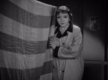 Movie still from “It Happened One Night” (1934), directed by Frank Capra – A black - and - white photo of a woman holding a curtain; Medium shot, High angle