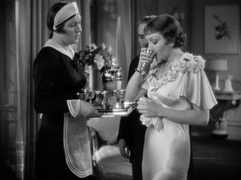 Movie still from “It Happened One Night” (1934), directed by Frank Capra – A woman holding a tray in front of two other women; Medium shot, High angle