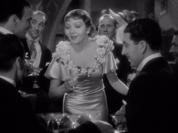 Movie still from “It Happened One Night” (1934), directed by Frank Capra – An old photo of a woman and a man at a party; Medium shot, Over the shoulder angle