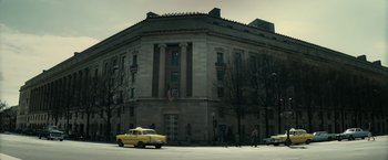 Movie still from “J. Edgar” (2011), directed by Clint Eastwood – A yellow car parked in front of an old building; Extreme Wide shot, Low angle