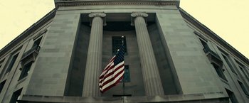 Movie still from “J. Edgar” (2011), directed by Clint Eastwood – An american flag flying in front of a building with columns; Extreme Wide shot, Low angle